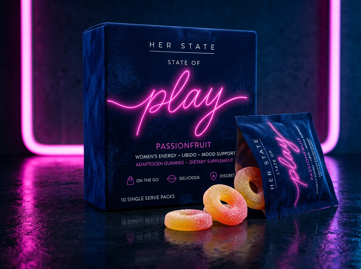 The Her State State of Play passionfruit box in navy velvet beside a torn single-serve packet and gummy rings, lit by a pink neon frame on polished concrete